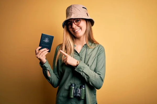 ブロンド観光女性とともに青い目オン休暇保持オーストラリアのパスポート使用双眼鏡非常に幸せなポインティングとともに手と指 — ストック写真
