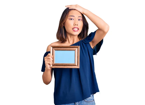 Young Beautiful Chinese Girl Holding Empty Frame Stressed Frustrated Hand — Stock Photo, Image