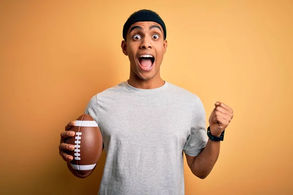 Joven Hombre Afroamericano Guapo Sosteniendo Pelota Rugby Sobre Fondo Amarillo —  Fotos de Stock