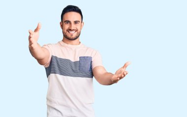 Mayo giyen genç yakışıklı adam ellerinin birarada dua ederek af diliyor kendinden emin bir şekilde gülümsüyor.. 