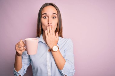Genç, güzel bir kadın, izole edilmiş pembe arka planda duran bir kupa kahve içiyor. Ağzını kapatıyor. Yanlışlıkla utancından, korkusunun dışavurumundan, sessizlikten, gizli konseptinden korkuyor.
