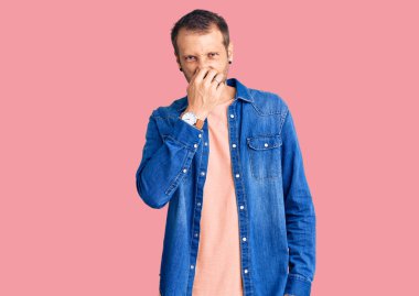 Sıradan kıyafetler giyen genç yakışıklı bir adam pis ve iğrenç bir koku alıyor, dayanılmaz bir koku, nefesini burnunda tutuyor. Kötü kokuyor. 