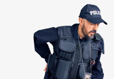 Polis üniforması giyen genç yakışıklı adam sırt ağrısı çekiyor, elleriyle dokunuyor, kas ağrısı çekiyor. 