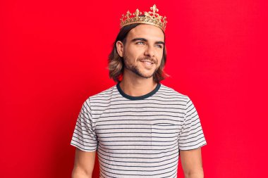 Prens tacı takan genç yakışıklı bir adam. Taraf arıyor, rahat bir poz veriyor, doğal bir yüz ve kendine güvenen bir gülümseme.. 