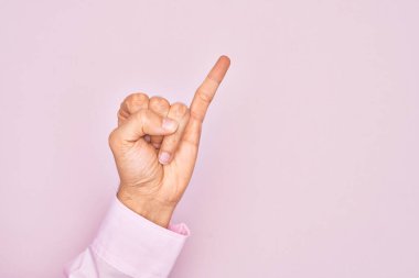 İzole edilmiş pembe arka planda parmaklarını gösteren beyaz bir gencin eli serçe parmağının söz verme sözü olduğunu gösteriyor.
