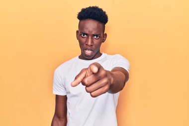 Genç, Afro-Amerikan bir adam, gündelik giysiler içinde kameraya kızgın ve hayal kırıklığına uğramış bir şekilde bakıyor. 