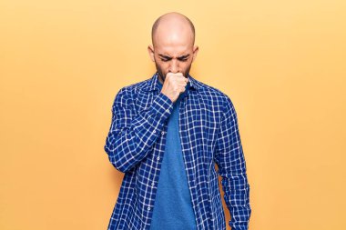 Genç yakışıklı, kel bir adam, gündelik tişört giyip kendini iyi hissetmiyor ve soğuk algınlığı ya da bronşitin belirtisi olarak öksürüyor. sağlık hizmeti kavramı. 