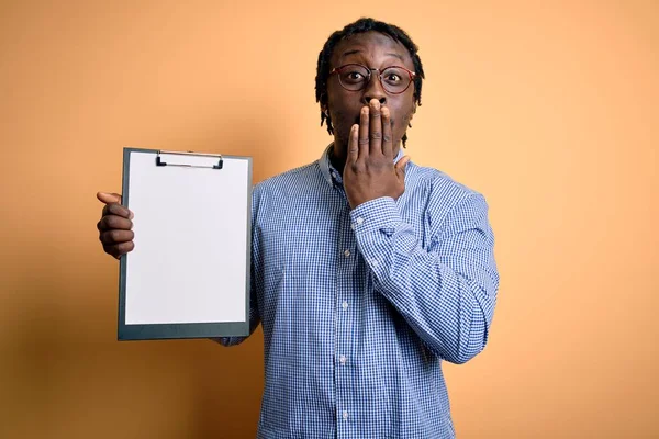 若いアフリカ系アメリカ人の検査官は クリップボードのチェックリストを保持眼鏡を身に着けている男は 恐怖の表現 沈黙の中で怖がって 秘密の概念でショックを受けた手で口をカバー — ストック写真