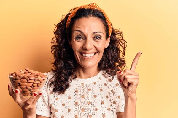 Mulher Meia Idade Bonita Segurando Tigela Com Amêndoas Sorrindo Feliz — Fotografia de Stock