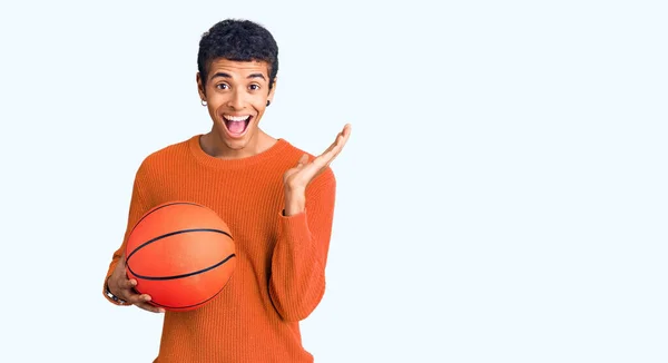 Молодой Афроамериканец Держащий Баскетбольный Мяч Празднующий Победу Счастливой Улыбкой Выражением — стоковое фото