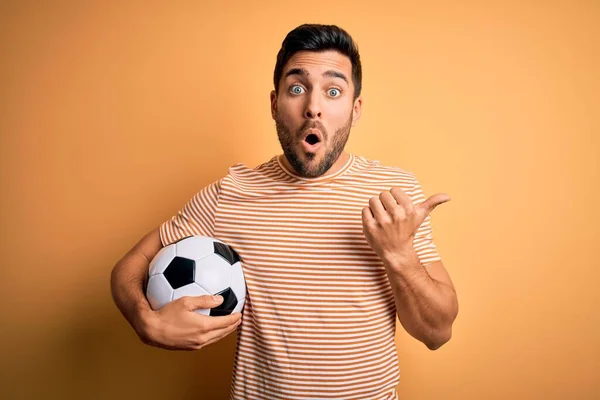 Sarı Zemin Üzerinde Futbol Topu Tutan Sakallı Yakışıklı Oyuncu Elinle — Stok fotoğraf