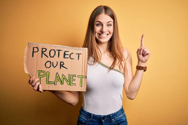 기사보기 여자가 지구를 보호하기 현수막을 얼굴로 손가락을 가리키는 아이디어나 질문에 — 스톡 사진