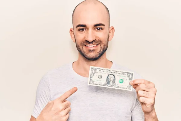 Joven Hombre Calvo Guapo Sosteniendo Billete Dólar Sonriendo Feliz Señalando —  Fotos de Stock