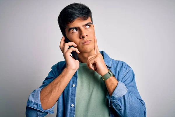 Mladý Pohledný Muž Mluvící Chytrém Telefonu Nad Bílým Pozadím Vážný — Stock fotografie