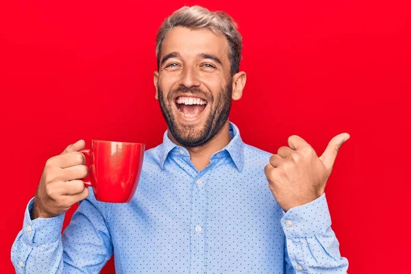 Joven Hombre Rubio Guapo Con Barba Bebiendo Taza Roja Café — Foto de Stock