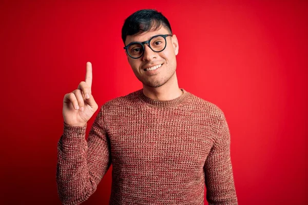Mladý Pohledný Hispánec Brýlích Červeném Pozadí Ukazující Prstem Nahoru Úspěšným — Stock fotografie