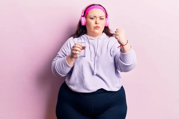 Jovem Size Mulher Bebendo Copo Água Usando Fones Ouvido Irritado — Fotografia de Stock