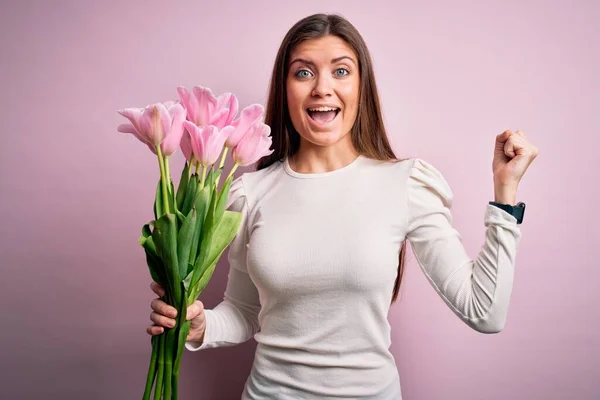 Young beautiful romantic woman with blue eyes holding beauty bouquet of pink tulips screaming proud and celebrating victory and success very excited, cheering emotion — Stock Image Young Beautiful Romantic Woman Blue Eyes Holding Beauty Bouquet Pink Stock Picture