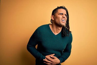 Genç, yakışıklı Afro-Amerikan Afrikalı, rastalı yeşil kazaklı, midesi bulanan, acı verici bir hastalıktan dolayı yeşil kazak giyen adam. Ache kavramı.