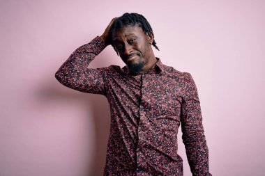 Genç, yakışıklı, Afro-Amerikan bir adam pembe arka planda dikilip soru sormayı merak ediyor. Şüpheyle kararsız, kafa kafaya düşünerek. Düşünceli kavram.