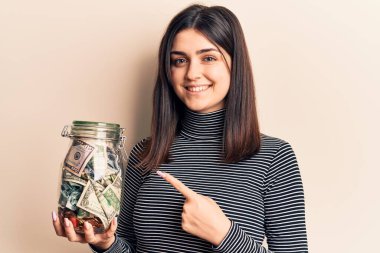 Bahşiş kavanozunu tutan genç ve güzel bir kız gülümsüyor. 