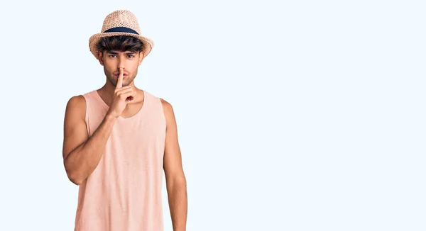 夏の帽子をかぶった若いヒスパニック系の男性が唇に指で静かにするように求めています 沈黙と秘密の概念 — ストック写真