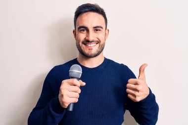 Mayo giyen genç yakışıklı adam ellerinin birarada dua ederek af diliyor kendinden emin bir şekilde gülümsüyor.. 