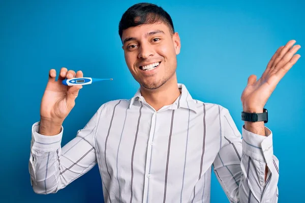 Jeune Homme Hispanique Tenant Thermomètre Température Médicale Sur Fond Bleu — Photo