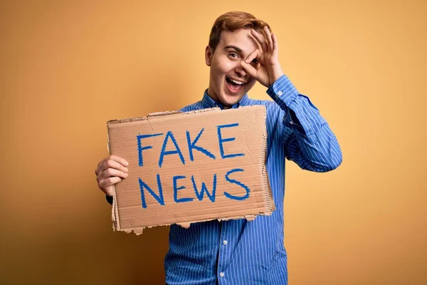 Ung Stilig Rödhårig Man Håller Banner Med Falska Nyheter Meddelande — Stockfoto