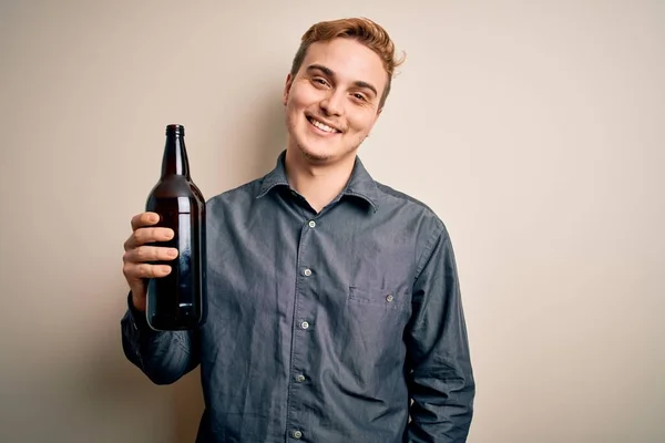 Mladý Pohledný Ryšavý Muž Pití Láhev Piva Přes Izolované Bílé — Stock fotografie
