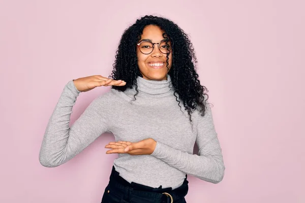 Jonge Afro Amerikaanse Vrouw Draagt Coltrui Bril Roze Achtergrond Gebaren — Stockfoto