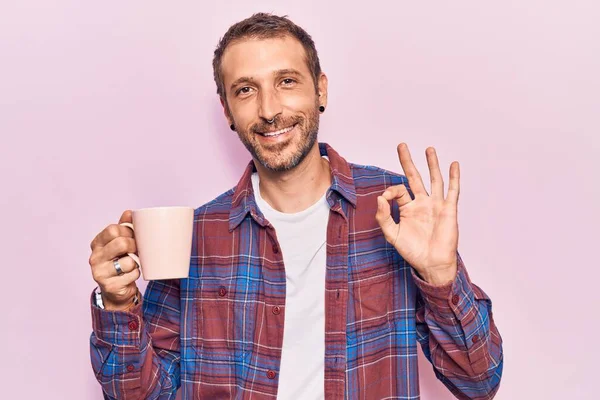 Joven Hombre Guapo Sosteniendo Café Haciendo Signo Con Los Dedos —  Fotos de Stock