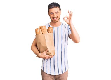 Elinde ekmek torbası olan yakışıklı genç adam. Tamam imzasını atıyor. Parmaklarıyla imzalıyor. 