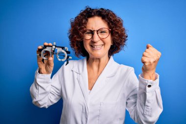 Mavi arka planda optik gözlük takan orta yaşlı bir kadın gururla haykırıyor ve zaferi ve başarıyı kutluyor.