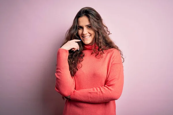 Młoda Piękna Kobieta Kręconymi Włosami Nosząca Sweter Golfem Różowym Tle — Zdjęcie stockowe