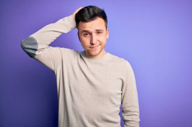 Mor izole bir arka plan üzerine günlük süveter giyen yakışıklı beyaz bir adam soru sorup kafasını karıştırıyor. Şüpheyle kararsız, kafa kafaya düşünerek. Düşünceli kavram.