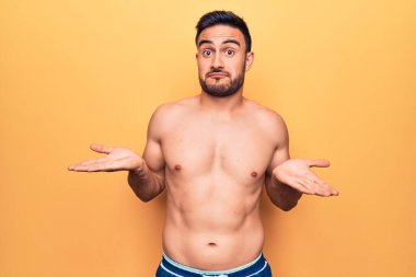 Mayo giyen genç yakışıklı adam ellerinin birarada dua ederek af diliyor kendinden emin bir şekilde gülümsüyor.. 