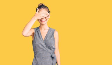 Sarı saçlı, iş kıyafetleri ve gözlük takan, gülümseyen ve gülen güzel beyaz kadın şaşırtmak için gözlerini kapatıyor. kör kavram. 