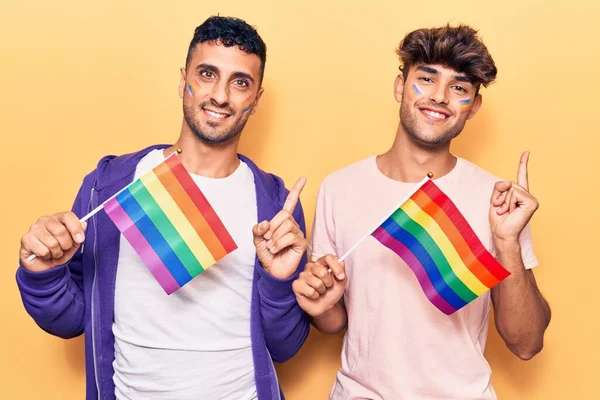 Joven Pareja Gay Sosteniendo Arco Iris Lgbtq Banderas Sonriendo Feliz — Foto de Stock