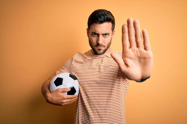 Sarı Arka Planda Futbol Topu Tutan Sakallı Yakışıklı Oyuncu Avuç — Stok fotoğraf