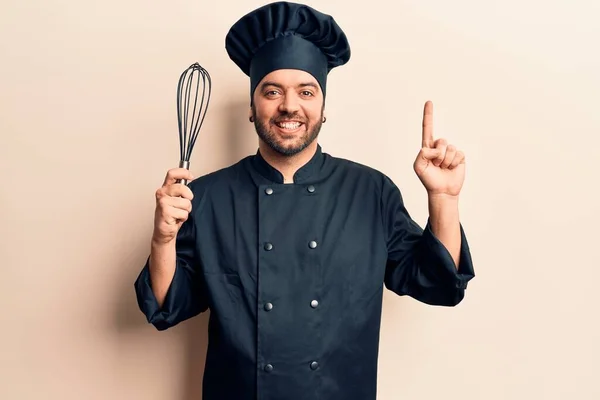 Joven Hispano Con Uniforme Cocina Sosteniendo Batidor Sonriendo Con Una — Foto de Stock
