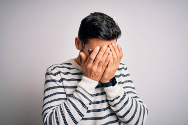 İzole edilmiş beyaz arka planda optometri gözlüğü takan sakallı yakışıklı genç bir adam. Ağlarken suratını ellerle kapatan üzgün bir ifade. Depresyon kavramı.