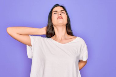 Genç, güzel, esmer bir kadın. Mor arka planda günlük beyaz tişört giyiyor. Boyun ağrısı çekiyor.