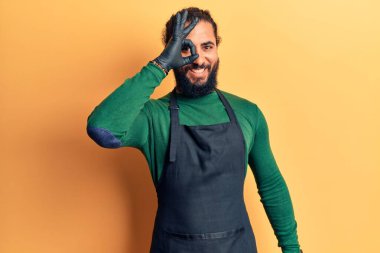 Berber önlüğü takan genç Arap adam gülümsüyor. Mutluluktan gülümsüyor. 