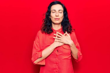 Gündelik kıyafetler giyen, göğsünde elleri kapalı, yüzünde minnet dolu bir jest olan genç ve güzel bir İspanyol kadın. sağlık kavramı. 