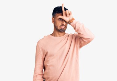 Latin asıllı genç adam sıradan kıyafetler giyiyor. Alnında parmakları olan insanlarla dalga geçiyor. Ezik hareketler yapıyor, alay ediyor, hakaret ediyor.. 