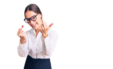 Beautiful brunette young woman wearing professional waitress apron showing middle finger doing fuck you bad expression, provocation and rude attitude. screaming excited 