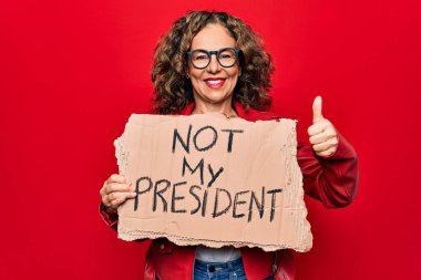 Orta yaşlı bir kadın demokrasi istiyor. Elinde benim başkanlık mesajım olmayan bir pankart. Mutlu ve olumlu gülümsüyor.