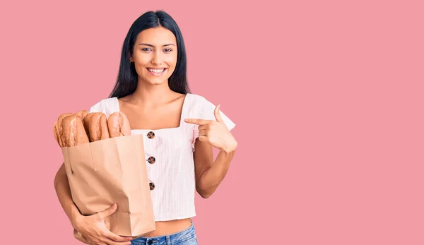 Jovem Bela Menina Latina Segurando Saco Papel Com Pão Apontando — Fotografia de Stock