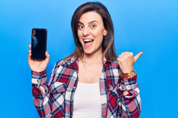 Młoda Piękna Kobieta Trzyma Smartfon Pokazując Ekran Wskazując Kciuk Góry — Zdjęcie stockowe